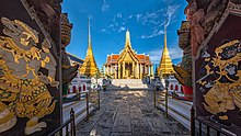 A Thai temple complex with several ornate buildings, and a lot of visitors