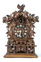 Carved spring-driven, mantel clock with bone hands, Gordian Hettich Sohn, Furtwangen, ca. 1870 (Deutsches Uhrenmuseum)