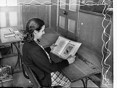 Girl reading a book featuring the title "The Children's Hour" and a photograph of a Hippopotamus in Thebarton Primary School, South Australia (1945)