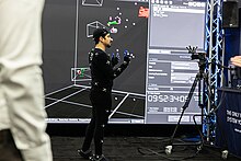 An exhibitor at SIGGRAPH 2023 demoing a full-body motion capture suit.
