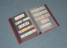 A photo album spread open to show a collection of stamps.