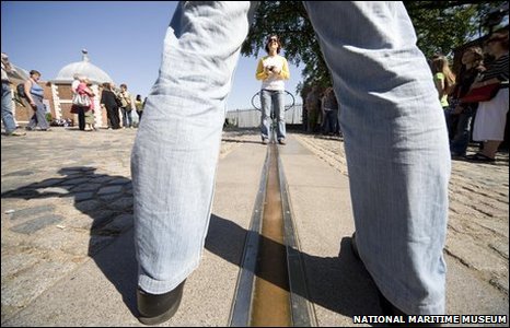 A visitor straddling the Greenwich Prime Meridian