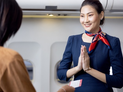 Stewardess welcoming passenger iStock-1311392163 - Uncredited