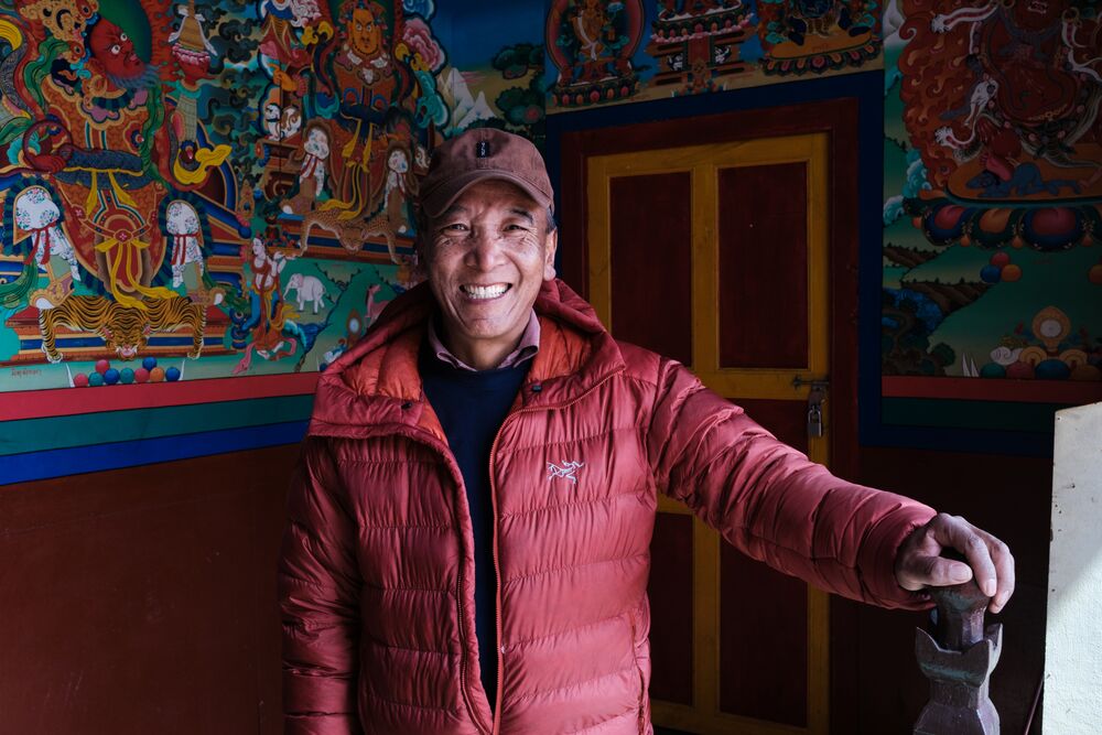 a man smiling at camera in a budhist monastery