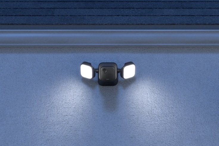 Blink Wire-Free Floodlight Camera mounted to house at night.