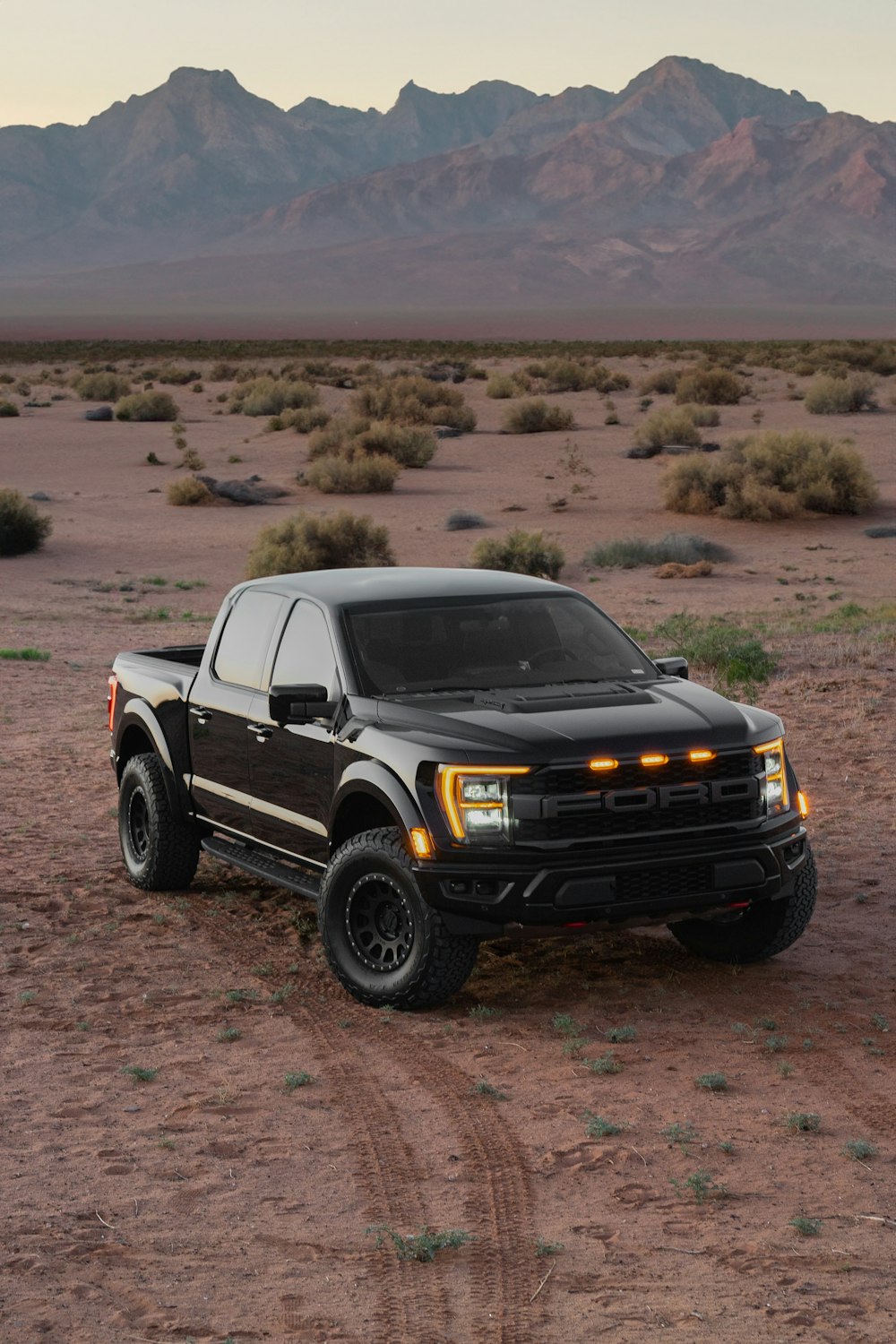 a black truck parked in the middle of a desert