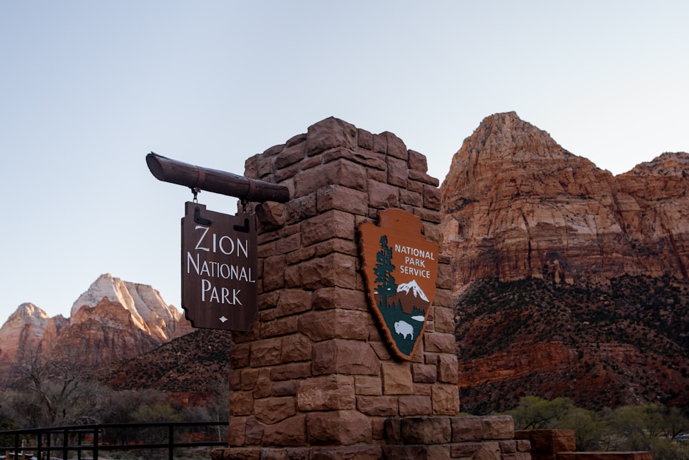 a sign for a national park with mountains in the background