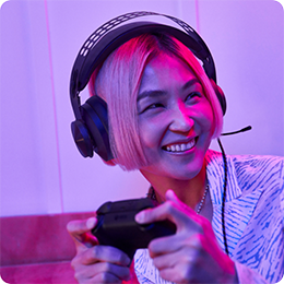 Person with short hair wearing headphones and holding a game controller