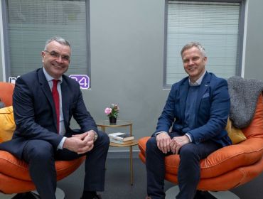 Two men in suits, Minister Dara Calleary, TD, and Buymedia CEO Fergal O'Connor, sit in chairs smiling at the camera.