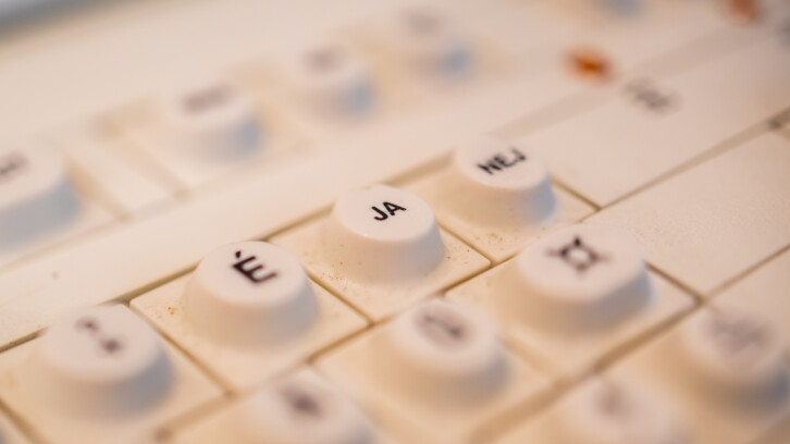 Gammaldags tangentbord med ovanliga tangenter, som "JA" och "É".
