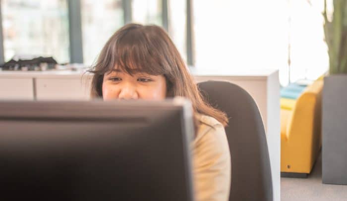 Kvinna arbetar framför dator på Internetstiftelsens kontor.