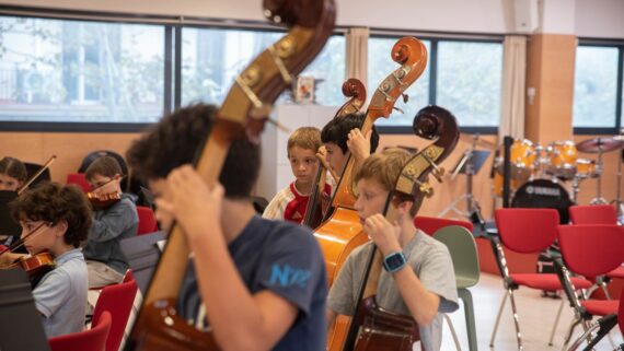 Infants tocant uns constrabaixos durant un concert d'instruments de corda a l'Escola Municipal de Música de l'Eixample