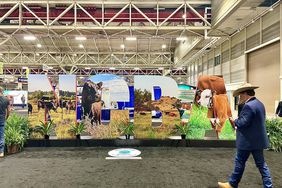 Cowboy walks in front of NCBA sign during the cattle convention.