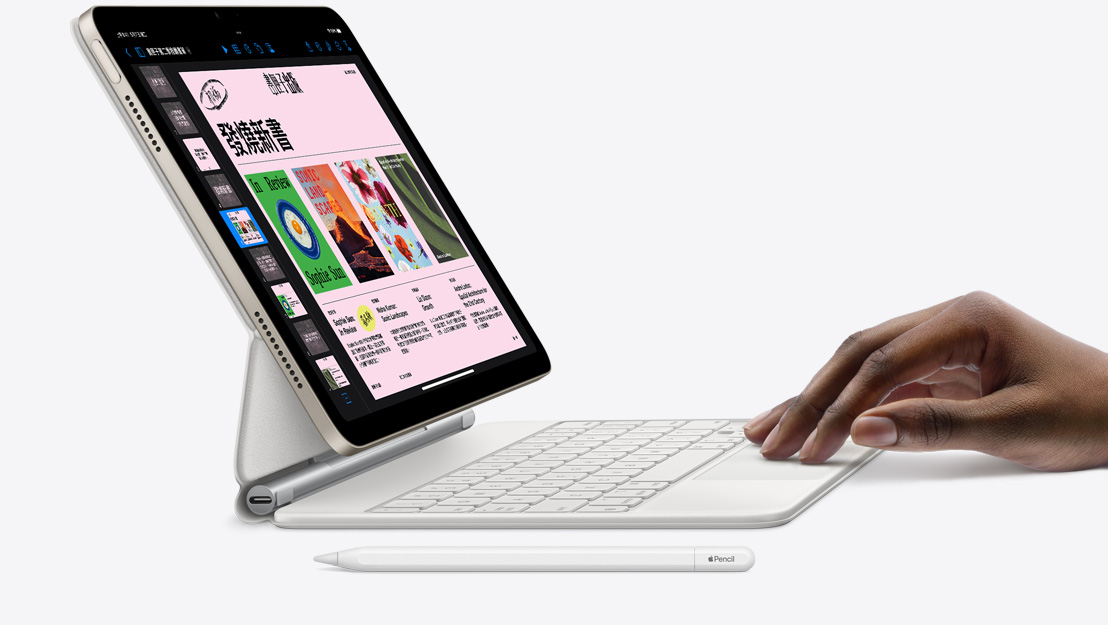 iPad Air 的側面圖，螢幕上顯示 Keynote app，並吸附著巧控鍵盤，一隻手放在觸控式軌跡板上，旁邊還有一支 Apple Pencil。