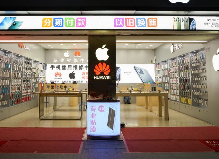 A store with the Apple and Huawei logos on it, and an image of an iPhone visible in the store.